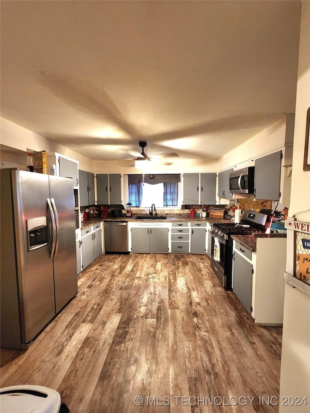 kitchen with hardwood / wood-style floors, gray cabinetry, sink, and stainless steel appliances