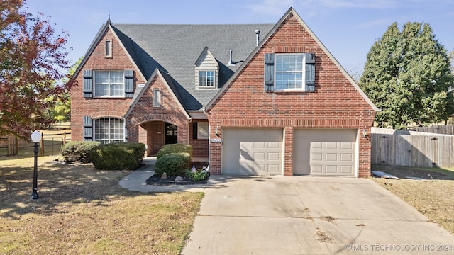 tudor-style house with a front yard and a garage