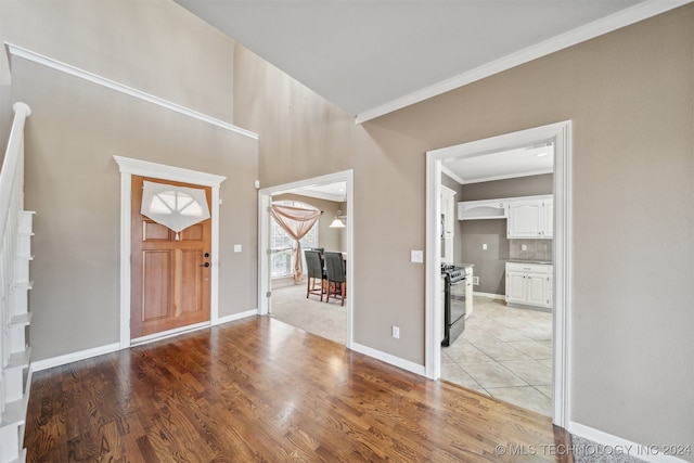 entryway with light hardwood / wood-style floors and ornamental molding