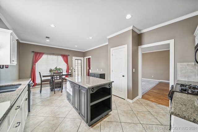 kitchen with white cabinetry, a center island, and light tile patterned floors