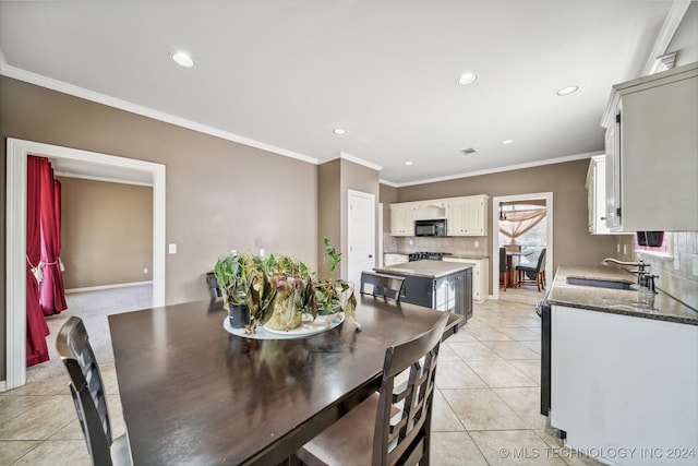 dining room with sink, light tile patterned flooring, and crown molding