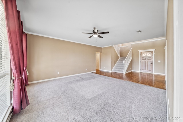 carpeted empty room featuring crown molding, a wealth of natural light, and ceiling fan