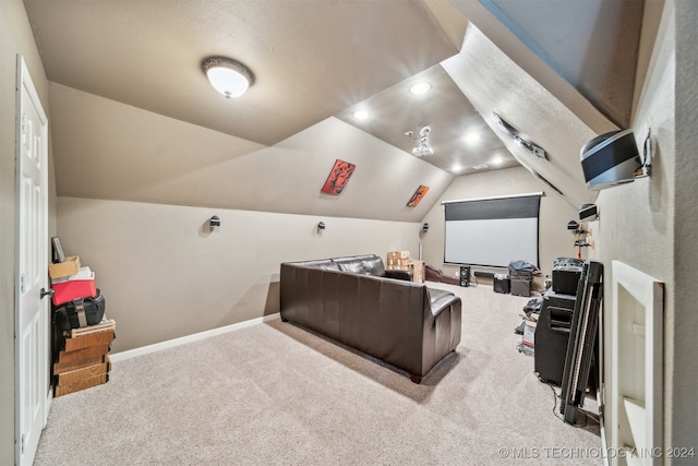 carpeted cinema room featuring vaulted ceiling