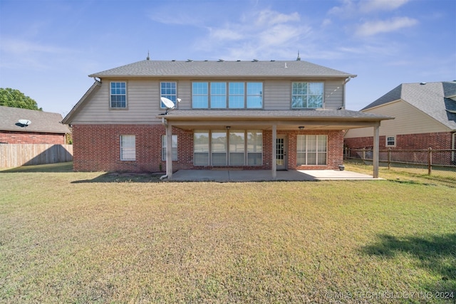 rear view of house featuring a yard and a patio