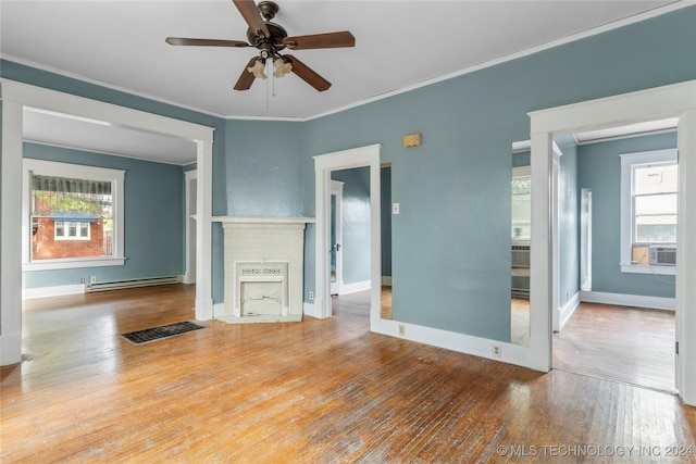 unfurnished living room with a baseboard radiator, ornamental molding, wood-type flooring, and a healthy amount of sunlight