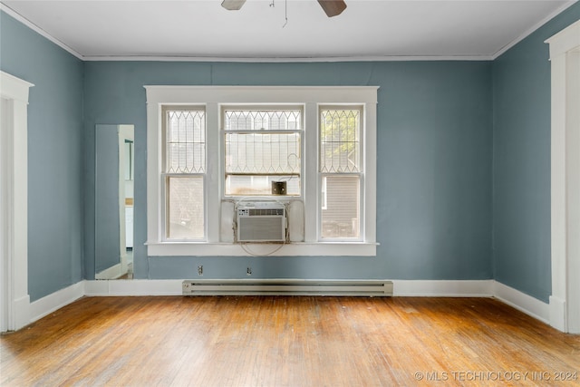 spare room featuring hardwood / wood-style floors, a baseboard heating unit, crown molding, and ceiling fan