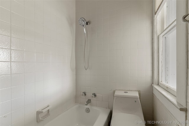 bathroom featuring toilet and tiled shower / bath combo