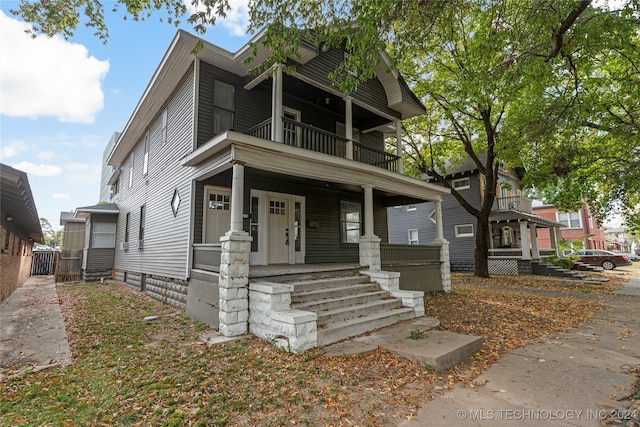 view of front of property with covered porch and a balcony