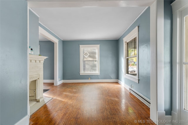 unfurnished living room featuring light hardwood / wood-style floors, crown molding, and a baseboard radiator