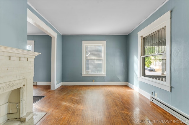 unfurnished living room with ornamental molding, a baseboard radiator, and light wood-type flooring