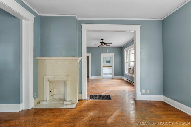 unfurnished living room featuring a baseboard heating unit, a brick fireplace, hardwood / wood-style floors, ceiling fan, and crown molding