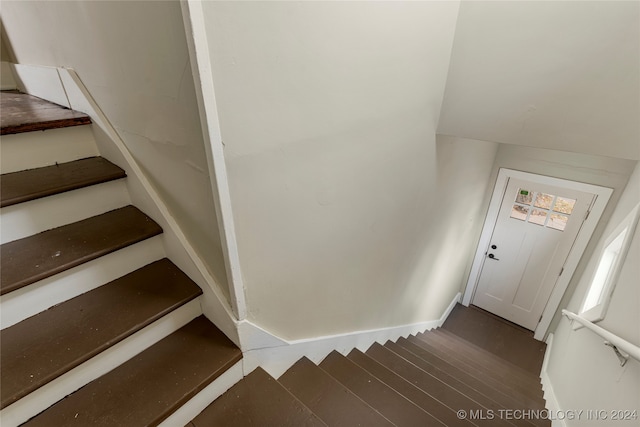 stairs featuring lofted ceiling and wood-type flooring