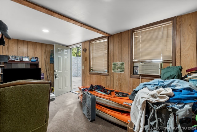 bedroom with cooling unit, light colored carpet, and wooden walls