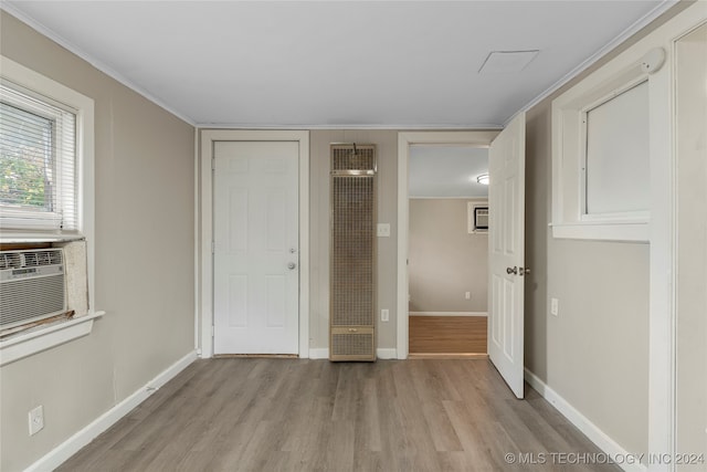 unfurnished bedroom featuring crown molding, cooling unit, and light wood-type flooring