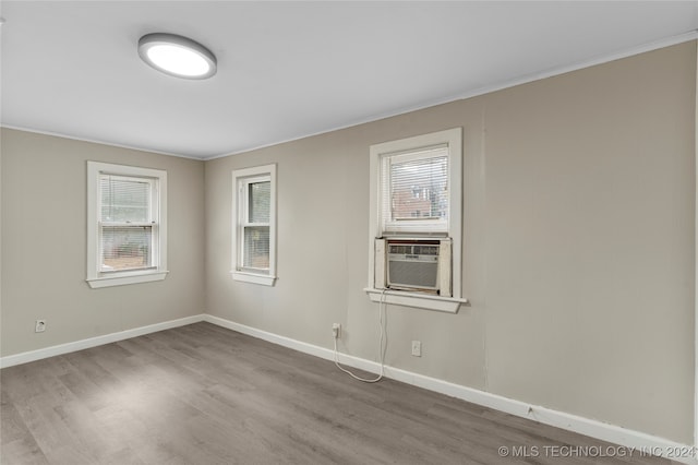 unfurnished room featuring crown molding, wood-type flooring, and cooling unit