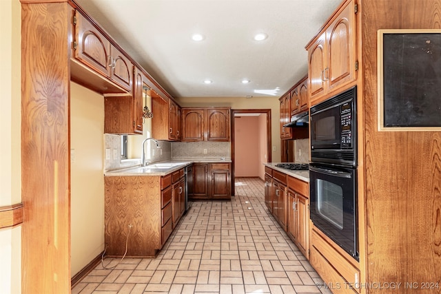 kitchen with black appliances, sink, and backsplash