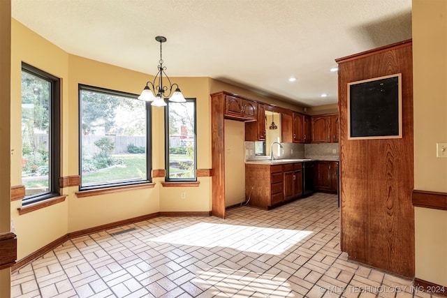 kitchen with decorative backsplash, black dishwasher, pendant lighting, a notable chandelier, and sink