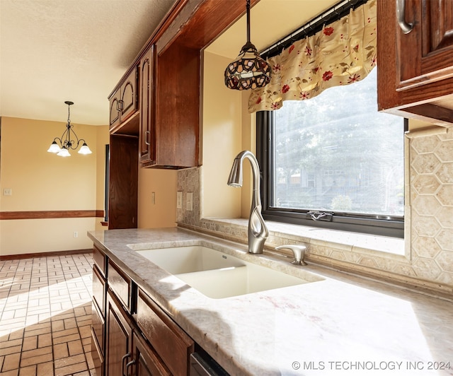 kitchen with an inviting chandelier, sink, and pendant lighting