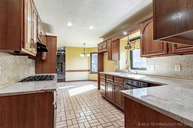 kitchen featuring gas cooktop, tasteful backsplash, decorative light fixtures, and sink