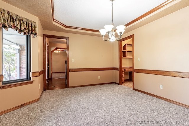 spare room featuring crown molding, a textured ceiling, carpet, and a tray ceiling