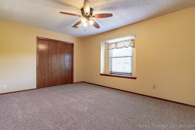 unfurnished bedroom featuring a closet, ceiling fan, a textured ceiling, and carpet floors