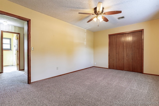 unfurnished bedroom featuring carpet floors, a textured ceiling, a closet, and ceiling fan