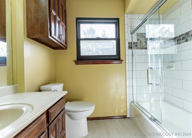 full bathroom with toilet, enclosed tub / shower combo, and vanity