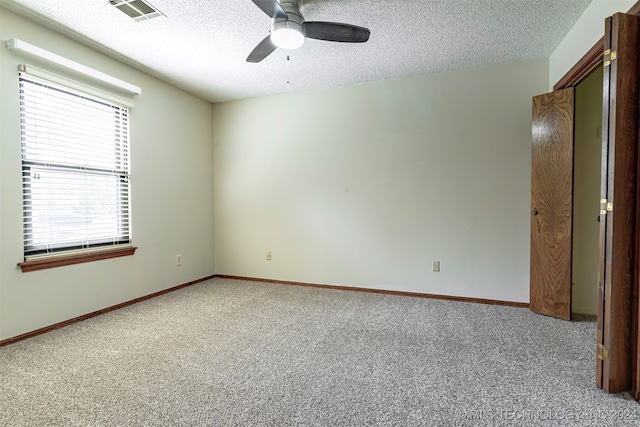 spare room with carpet, a textured ceiling, and ceiling fan