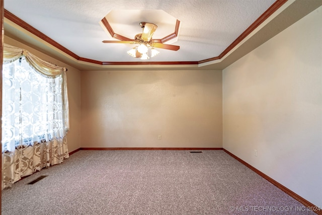 empty room featuring carpet floors, a tray ceiling, crown molding, a textured ceiling, and ceiling fan