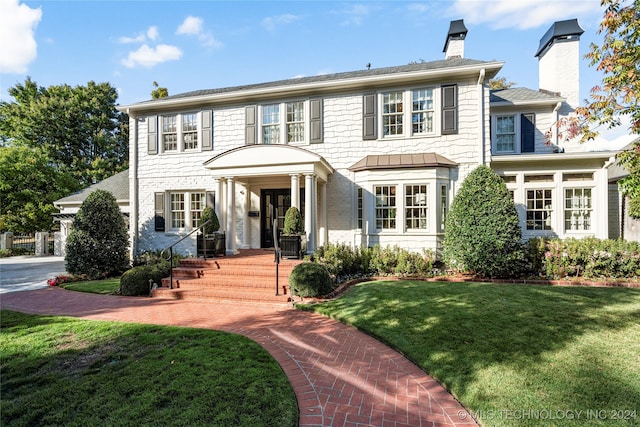 colonial-style house with a front lawn