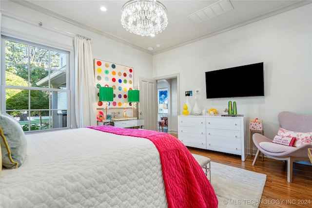 bedroom with an inviting chandelier, crown molding, and hardwood / wood-style flooring