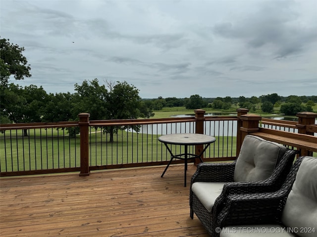 wooden deck featuring a lawn and a water view