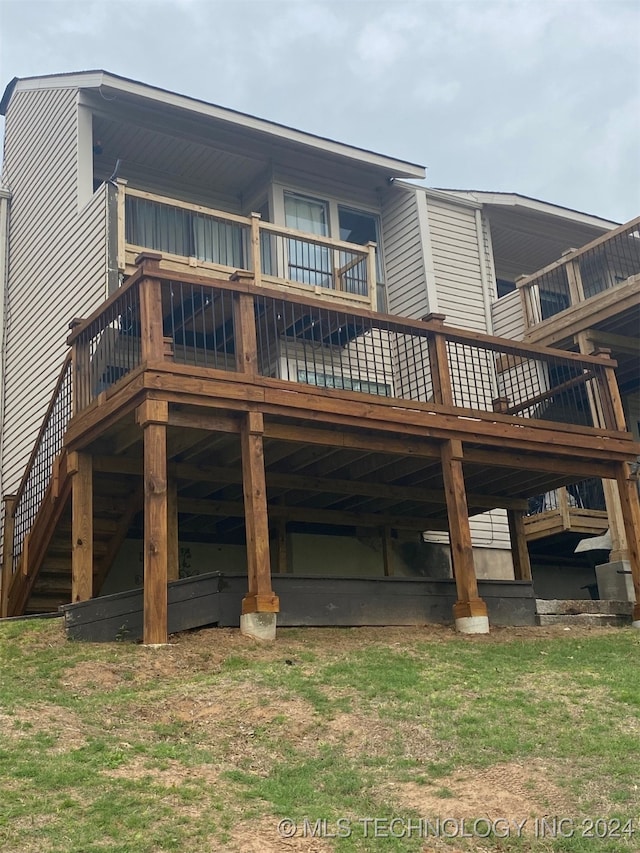 rear view of property with a lawn and a wooden deck