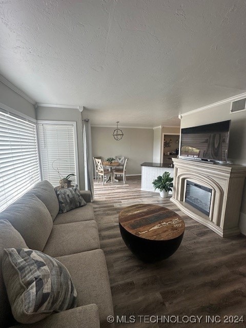 living room featuring a textured ceiling, hardwood / wood-style flooring, and crown molding