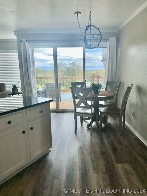 dining area featuring ornamental molding, dark hardwood / wood-style flooring, and a notable chandelier