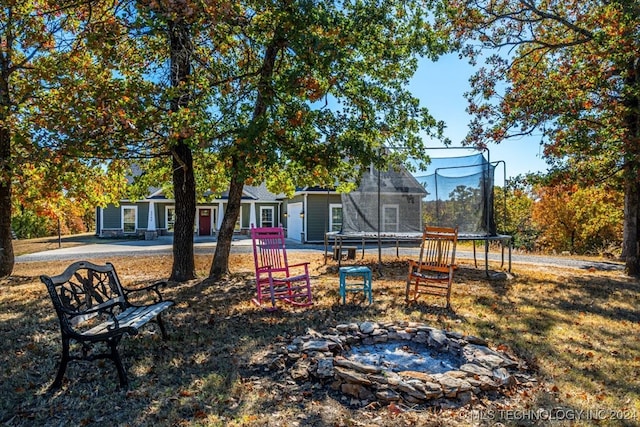 view of yard with a patio, a trampoline, and a fire pit