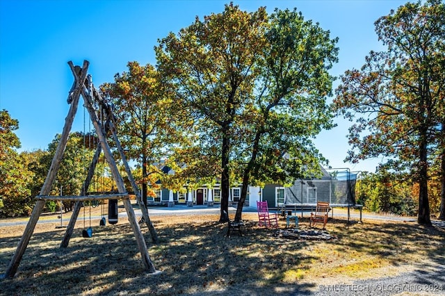 view of yard with a trampoline and a patio area