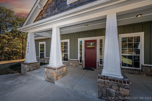 exterior entry at dusk featuring covered porch