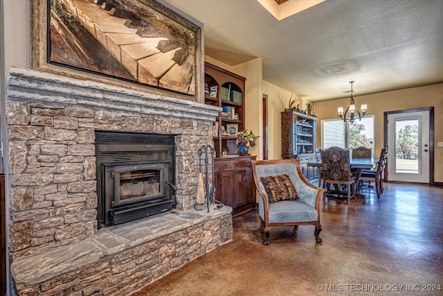 living area with a notable chandelier, a textured ceiling, and a fireplace