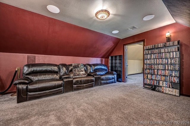 carpeted home theater featuring vaulted ceiling and a textured ceiling