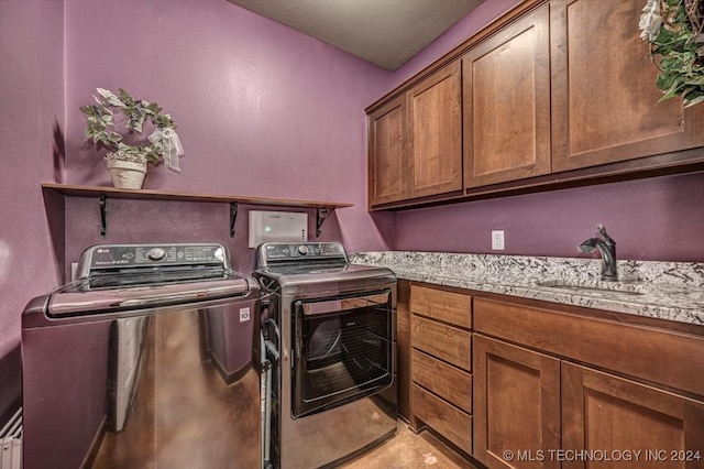 laundry room with sink, washer and dryer, and cabinets