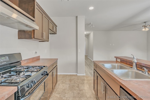 kitchen with wall chimney range hood, ceiling fan, stainless steel dishwasher, sink, and black gas range oven