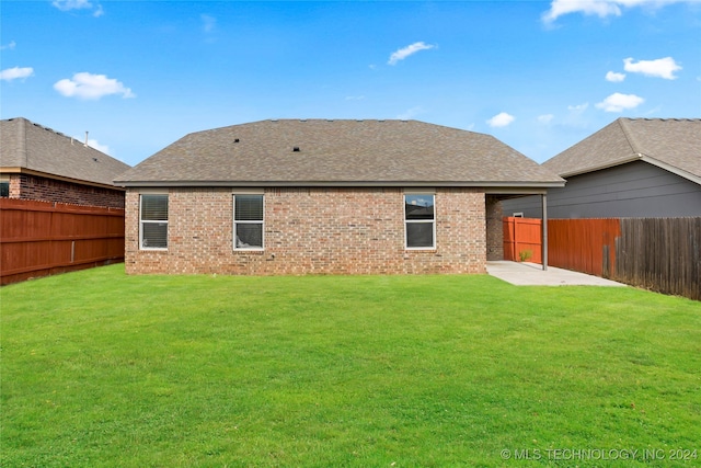 rear view of house with a patio and a lawn