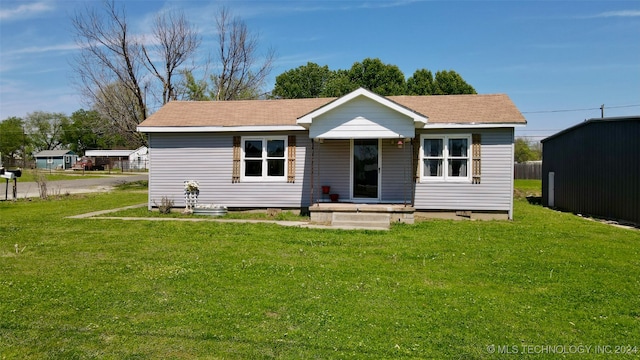 view of front of home featuring a shed and a front lawn