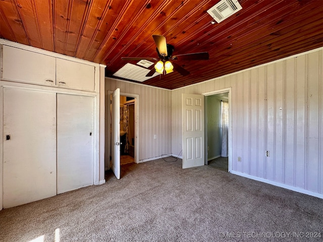 unfurnished bedroom featuring wood ceiling, a closet, light colored carpet, and ceiling fan