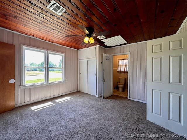 unfurnished bedroom featuring connected bathroom, wood ceiling, carpet floors, and ceiling fan