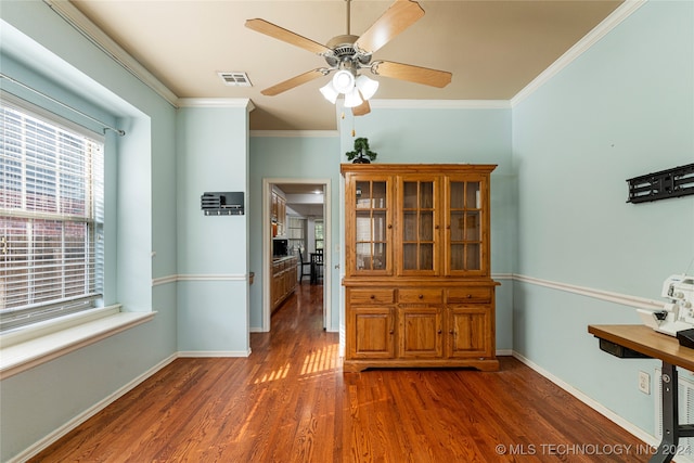 unfurnished dining area featuring crown molding, dark wood-type flooring, and ceiling fan