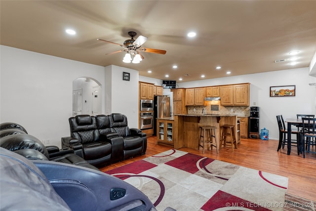 living room with light wood-type flooring and ceiling fan