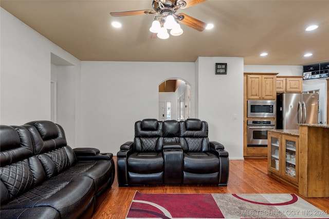 living room featuring ceiling fan and dark hardwood / wood-style flooring