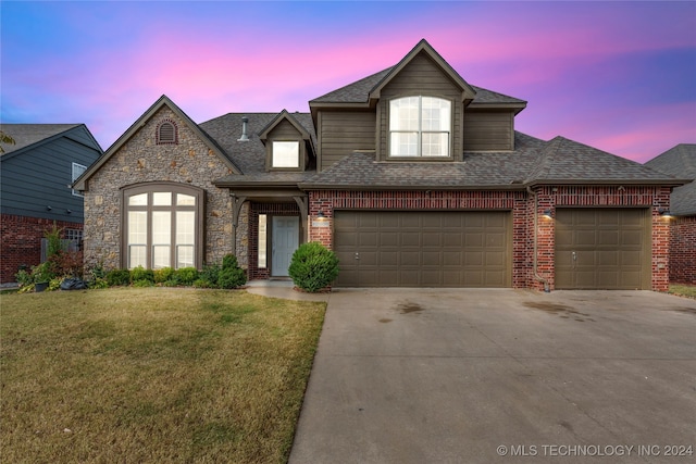 view of front of home with a yard and a garage